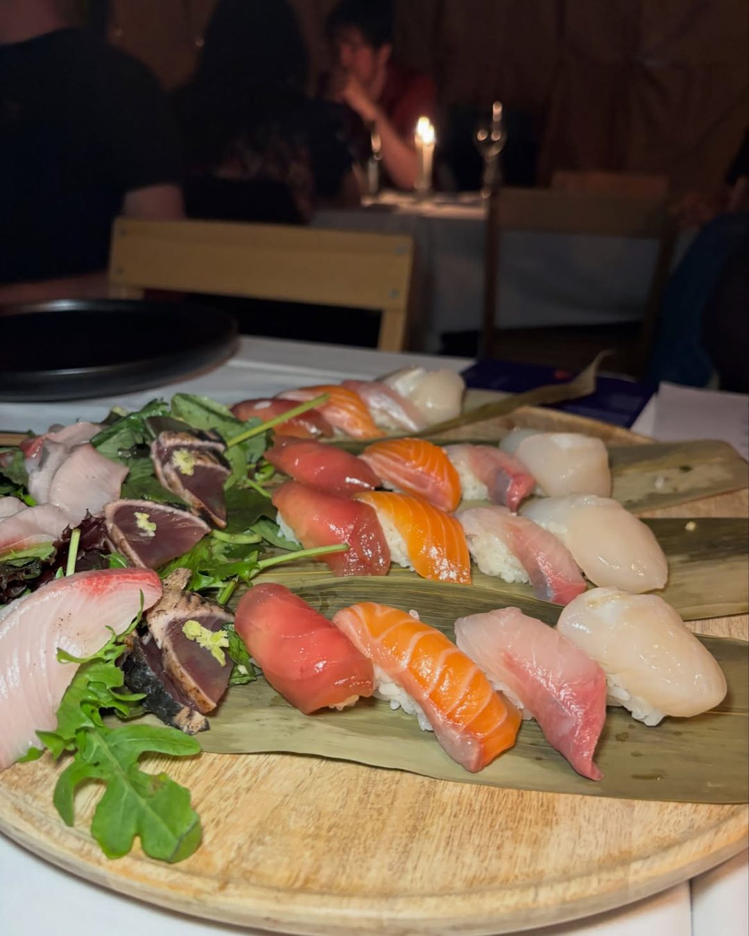 A board of nigiri and sashimi on bamboo leaves
