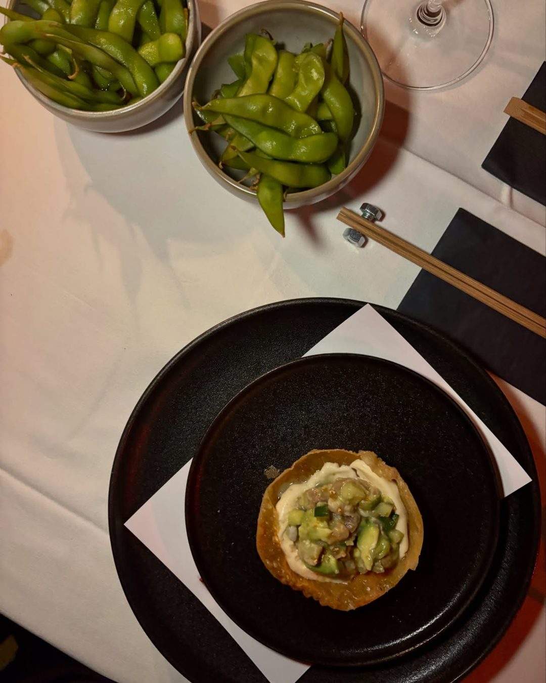 Edamame and a crisp tartare cup on a dark plate